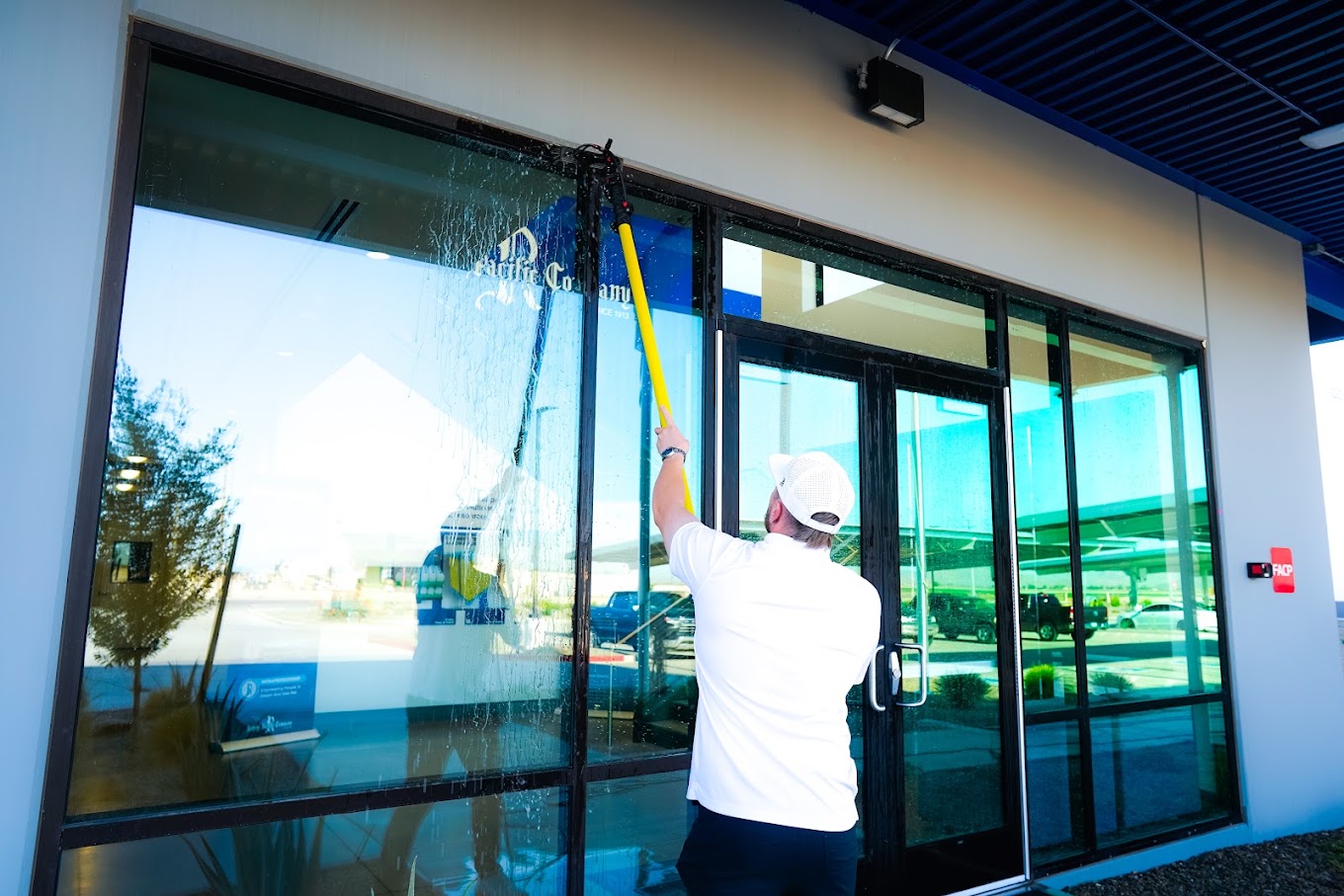 SunsUp technician cleaning the exterior windows of an Arizona home to a streak-free finish