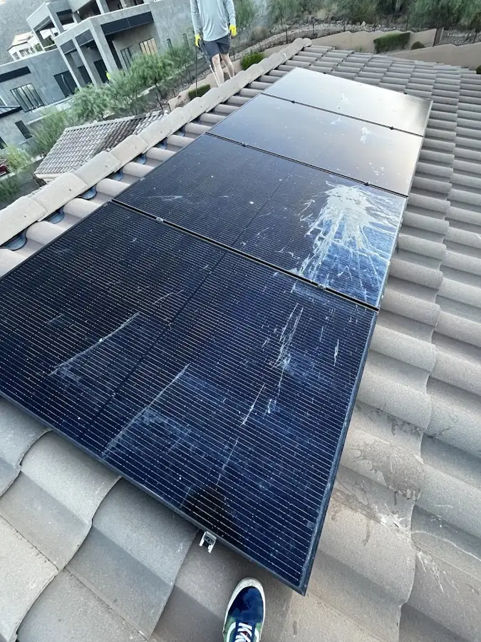 Solar panels covered in white pigeon droppings across the full length of the array